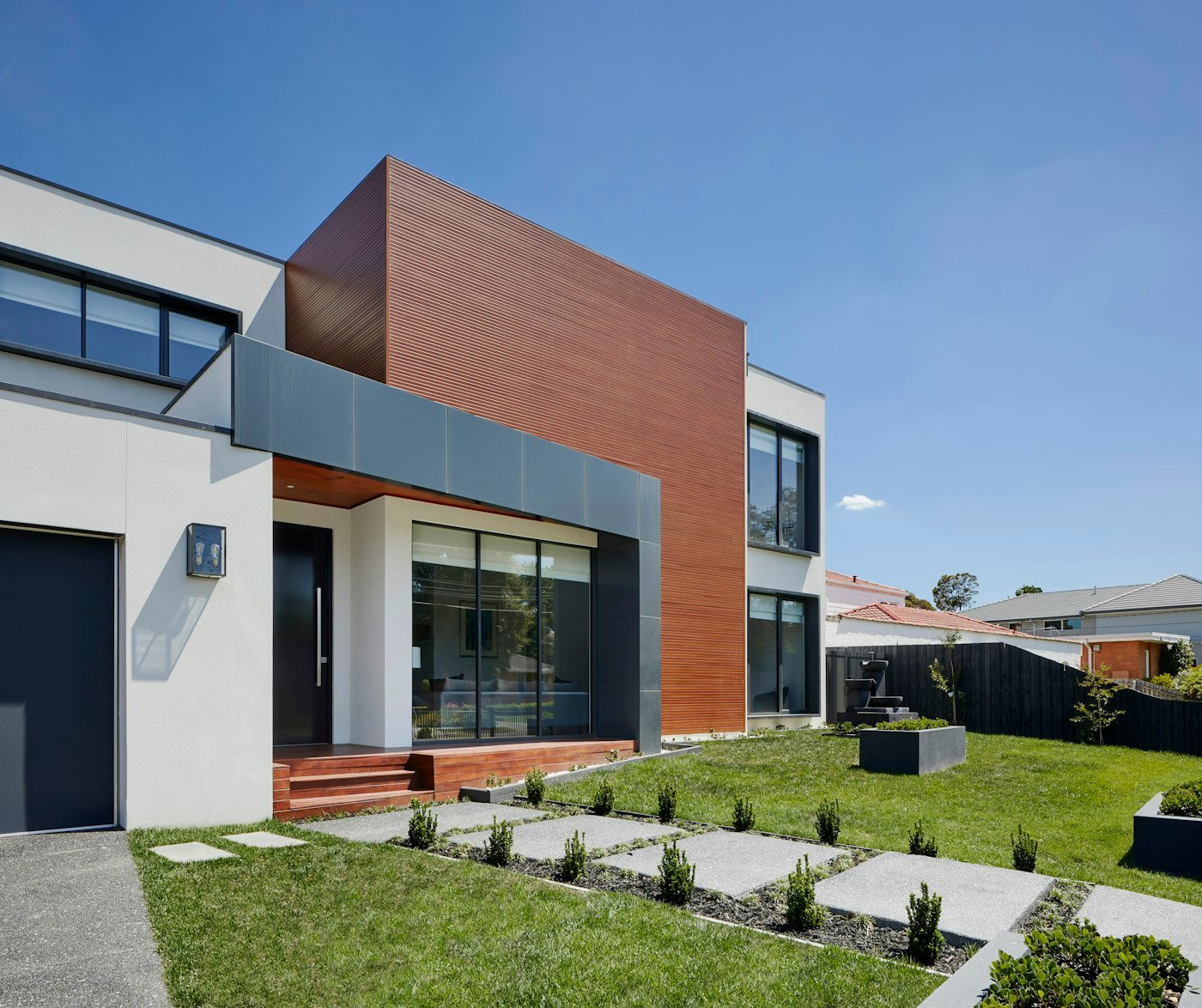 Modern two-storey house with timber and white cladding and a lawn
