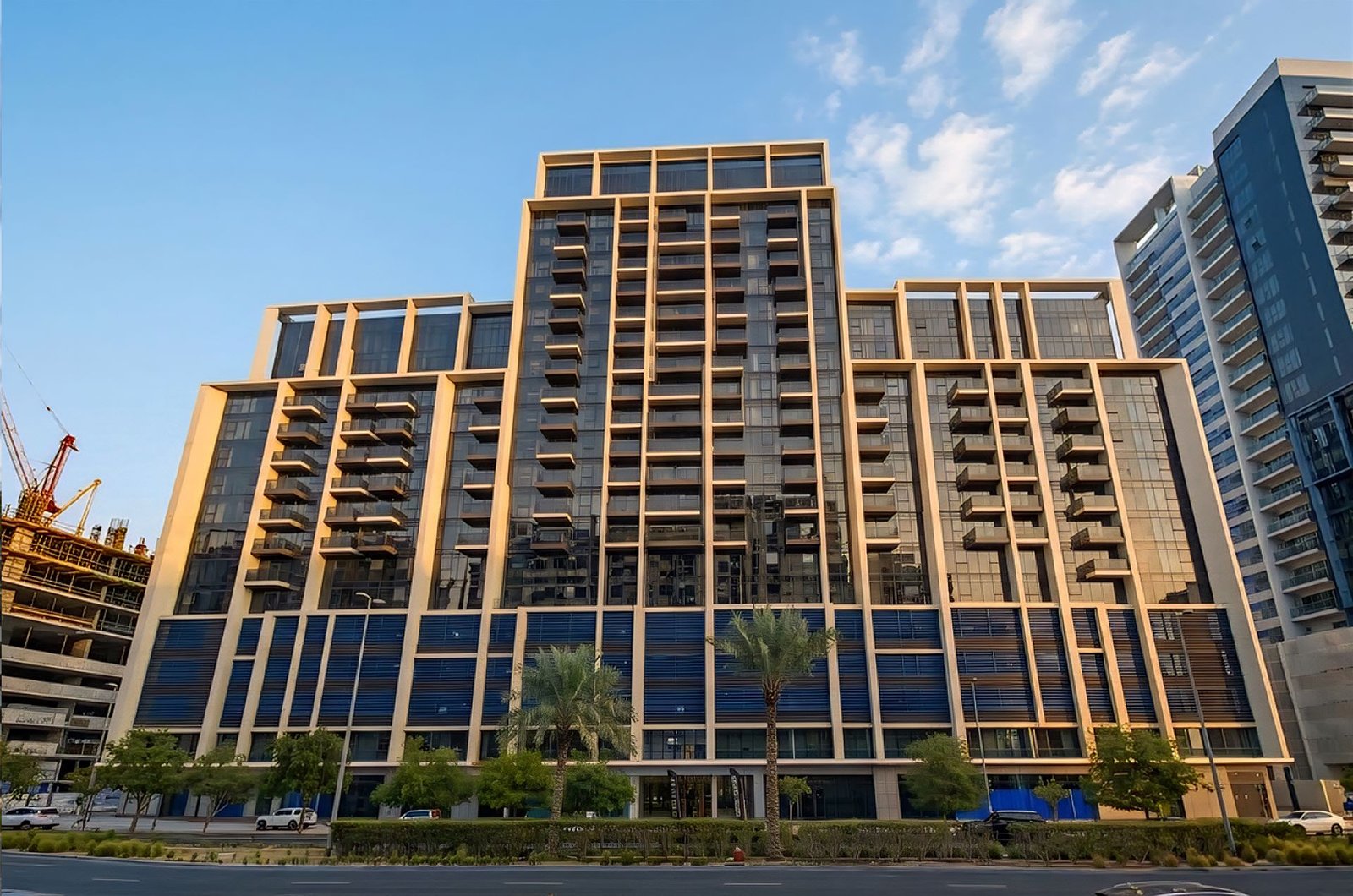 Neva Residences by Tiger Properties: mid-rise residential building with a gold-toned facade and balconies