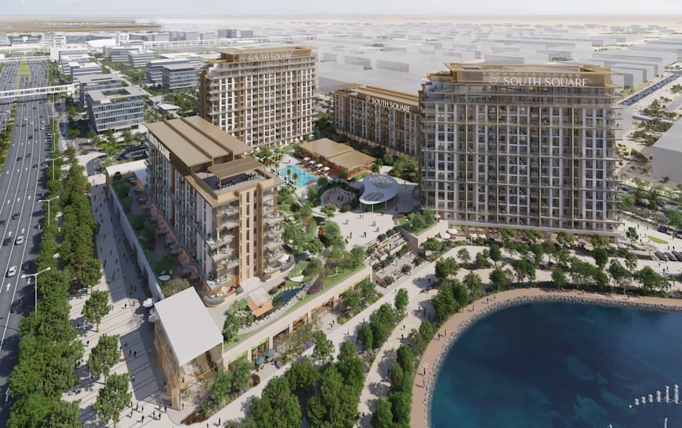 Aerial view of mid-rise mixed-use buildings and a landscaped promenade beside a lake, South Square, rendered view